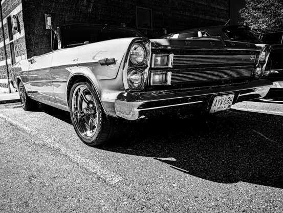 Oblique view looking at the front of a classic car: 1966 Ford Galaxie 500 7-Litre. Photo is black and white.