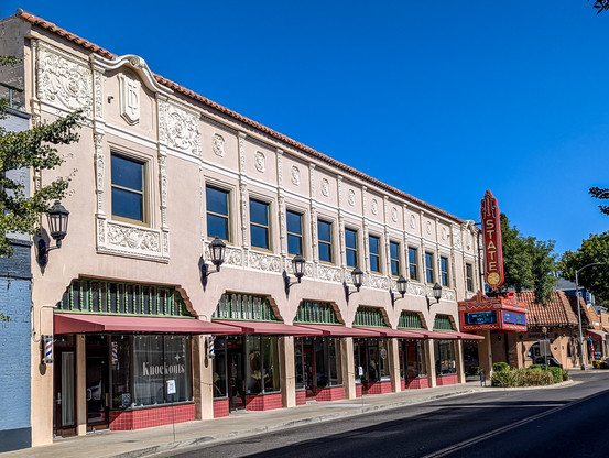 The Oroville State Theater - view of the exterior. 

https://www.orovillestatetheatre.com/

Built between 1927 and 1928, the State Theatre was designed by San Francisco architect Timothy Pflueger and opened its doors on April 7, 1928. It was one of several movie palaces owned and operated by the T&D chain throughout California, a number of which Pflueger designed for the company. The State Theatre was Oroville’s first Spanish Colonial Revival style building, one of only two high examples of the style in the city.

This style of architecture is growing increasingly rare in California. It was originally popular in California and Florida, but with a massive influx of population and the resulting implications to development, many of the original buildings in California were torn down to make way for new construction. Most of the remaining examples are tucked away in smaller communities where development has occurred at a slower rate and older buildings were left mostly intact. The Oroville State Theatre is one such example, but it is also an example of how limited small town resources make restoration and preservation difficult. It is vital that these communities make every effort to save, salvage, and protect these remaining structures.

